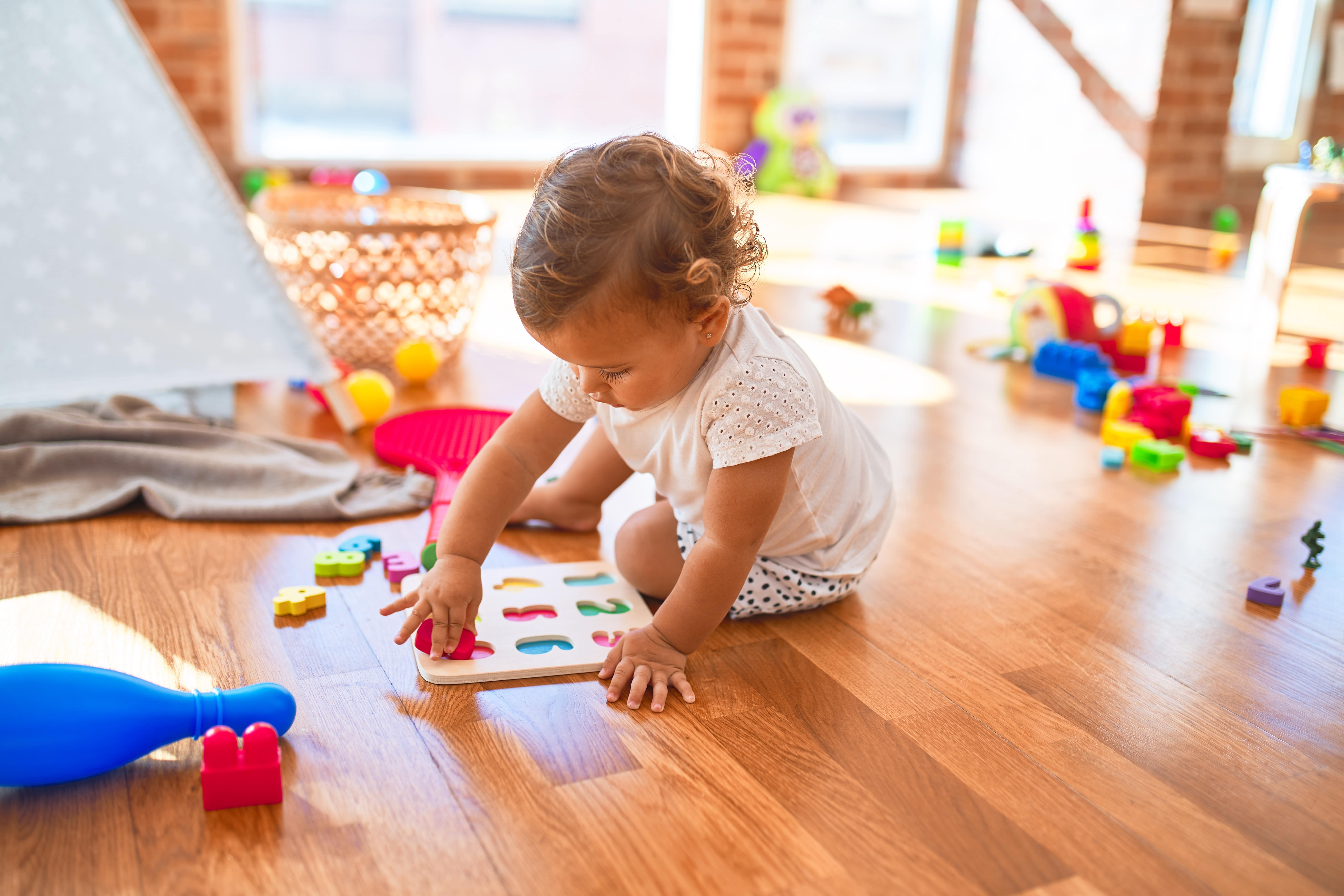 Kleinkind in der Kita mit Puzzle aus Holz